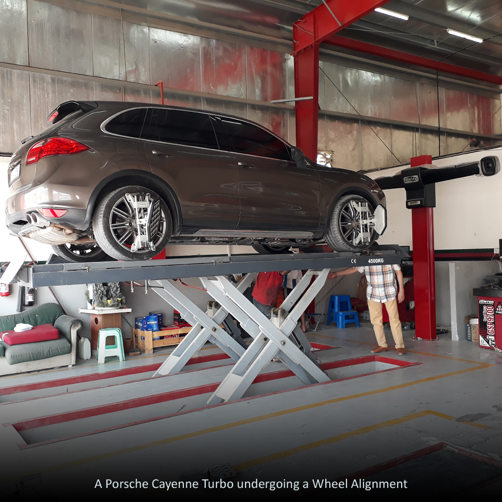 A picture showing a car getting a wheel alignment.